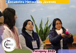 tres mujeres religiosas con una vela encendida, en actitud orante